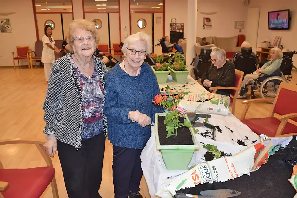 Deux résidentes présentant la jardinière qu'elles ont plantée