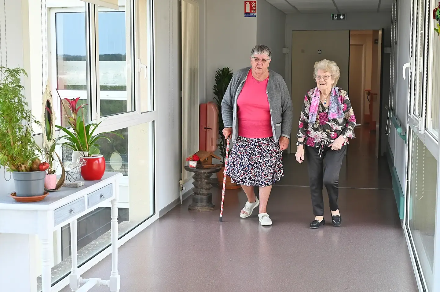 Deux résidentes marchant dans un couloir lumineux