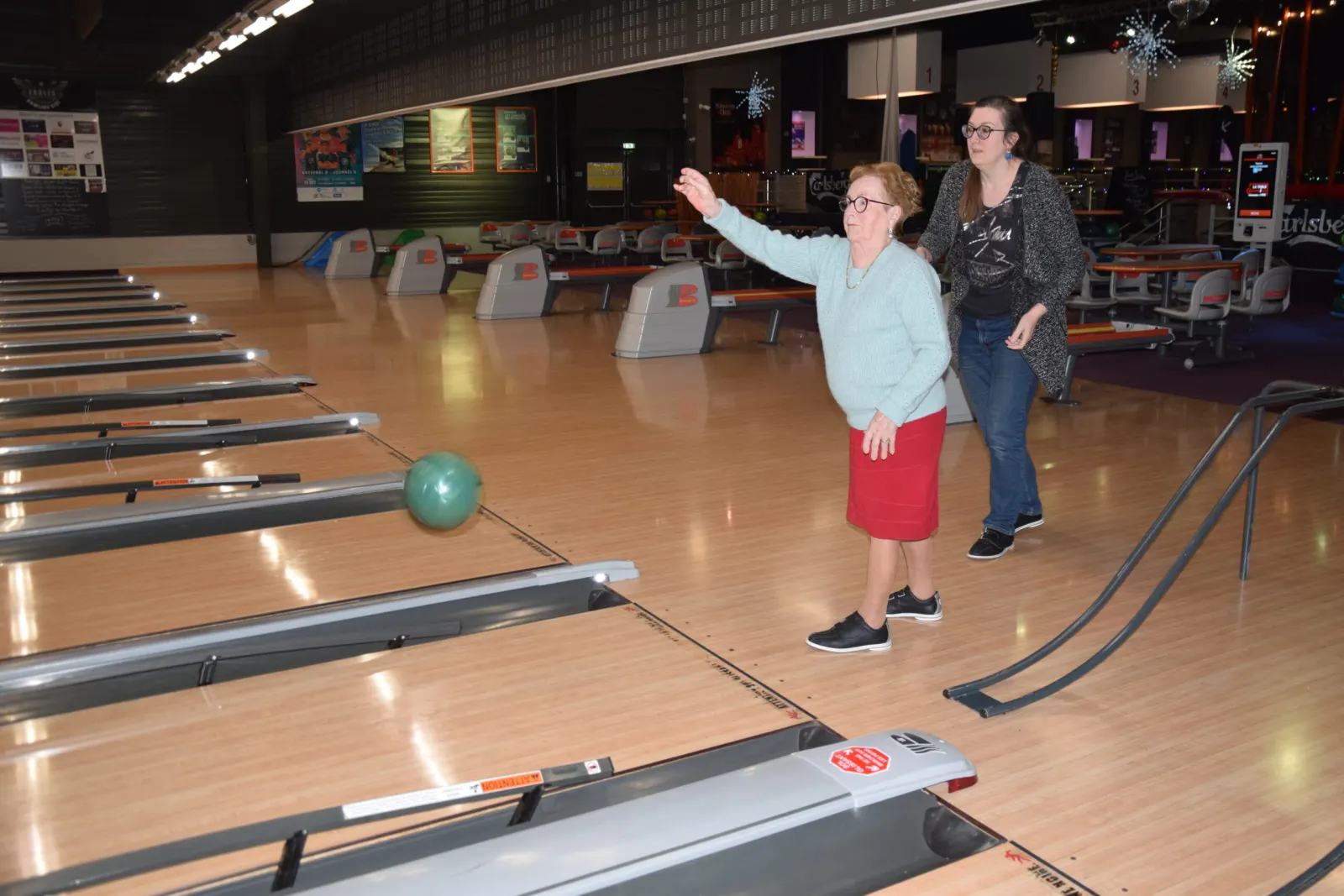 Résidente lançant une boule lors d'une sortie au bowling