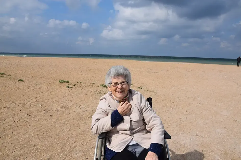 Résidente souriante sur une plage lors d'une sortie à la mer